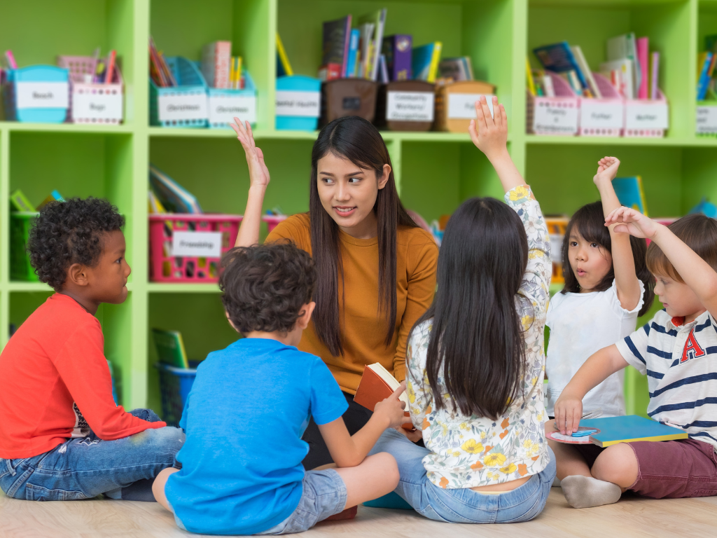 Teacher and children sitting on the floor in classroom